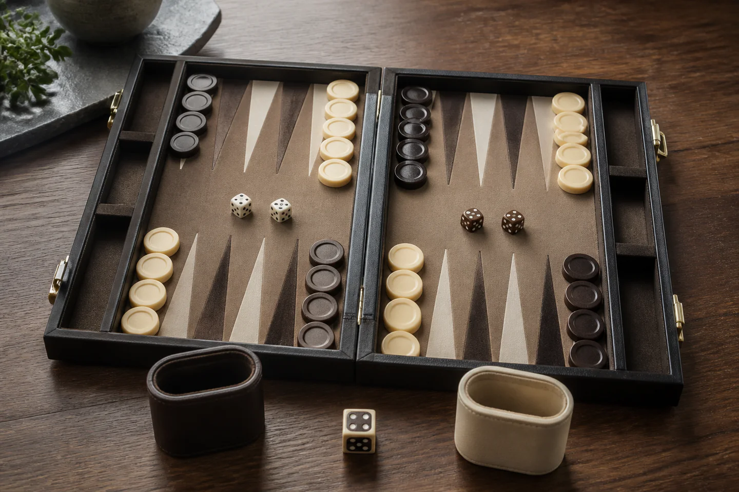Open backgammon board with correctly arranged checkers, dice cups and doubling cube beside a rule booklet