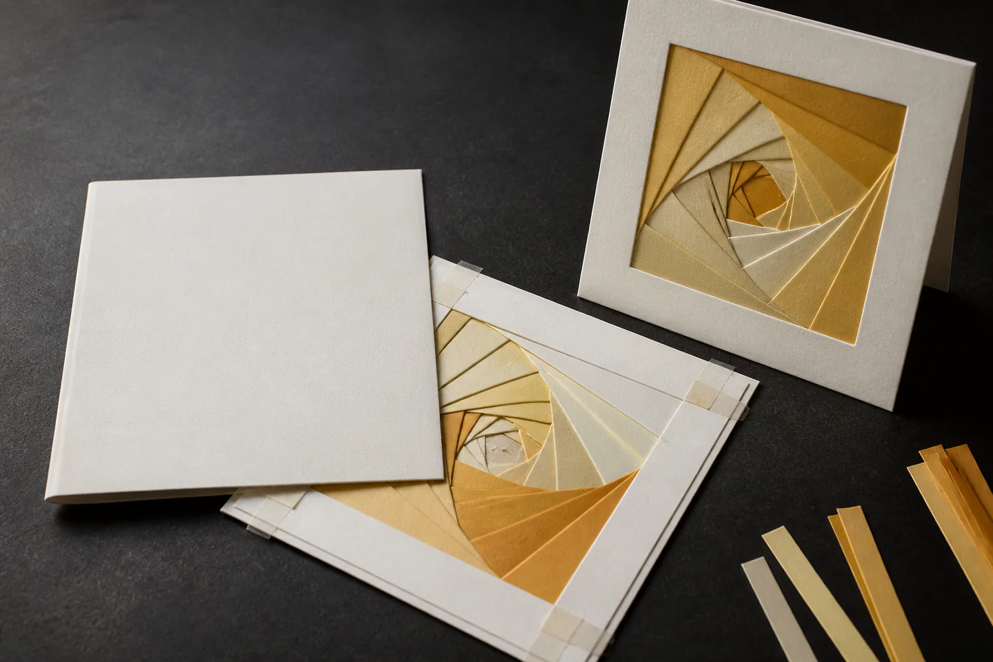 A handmade greeting card showing a neat spiral of layered coloured paper strips around a small centre window